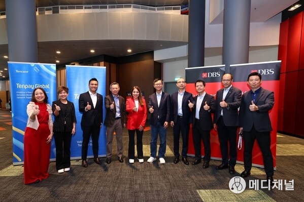 DBS Group CEO Tan Su Shan (centre in red) and Forest Lin (fifth from right), Corporate Vice President of Tencent and Head of Tencent Financial Technology, signed an MOU to enhance mutual cross-border payment connectivity at the Singapore FinTech Festival 2025.